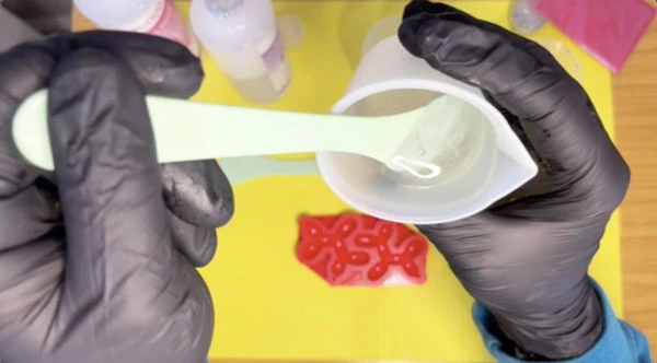 Close up of hands stirring resin mixture