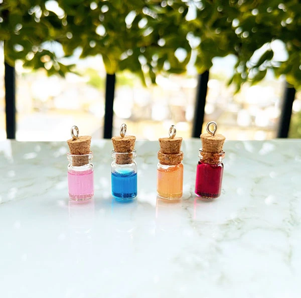 Small glass corked jars containing varying amounts of multicoloured resin