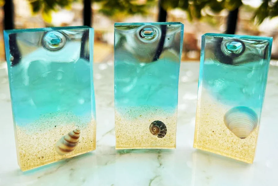 Sand and shells encased in blue resin charms