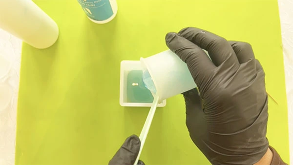 Blue resin being poured into a silicone mould