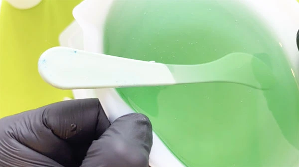 Close up of a large container full of green resin