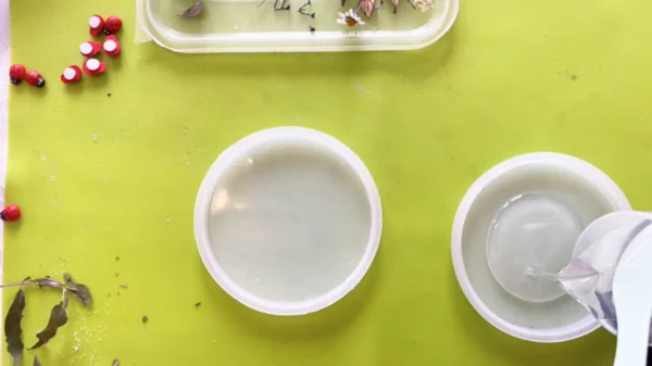 Clear resin being poured into a circular silicone mould